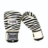 Angled view of white and black ThaiSmai FBG124-Zebra Muay Thai boxing gloves showing the zebra-striped padded knuckles, ergonomic glove shape and hook-and-loop wrist closures on a white background