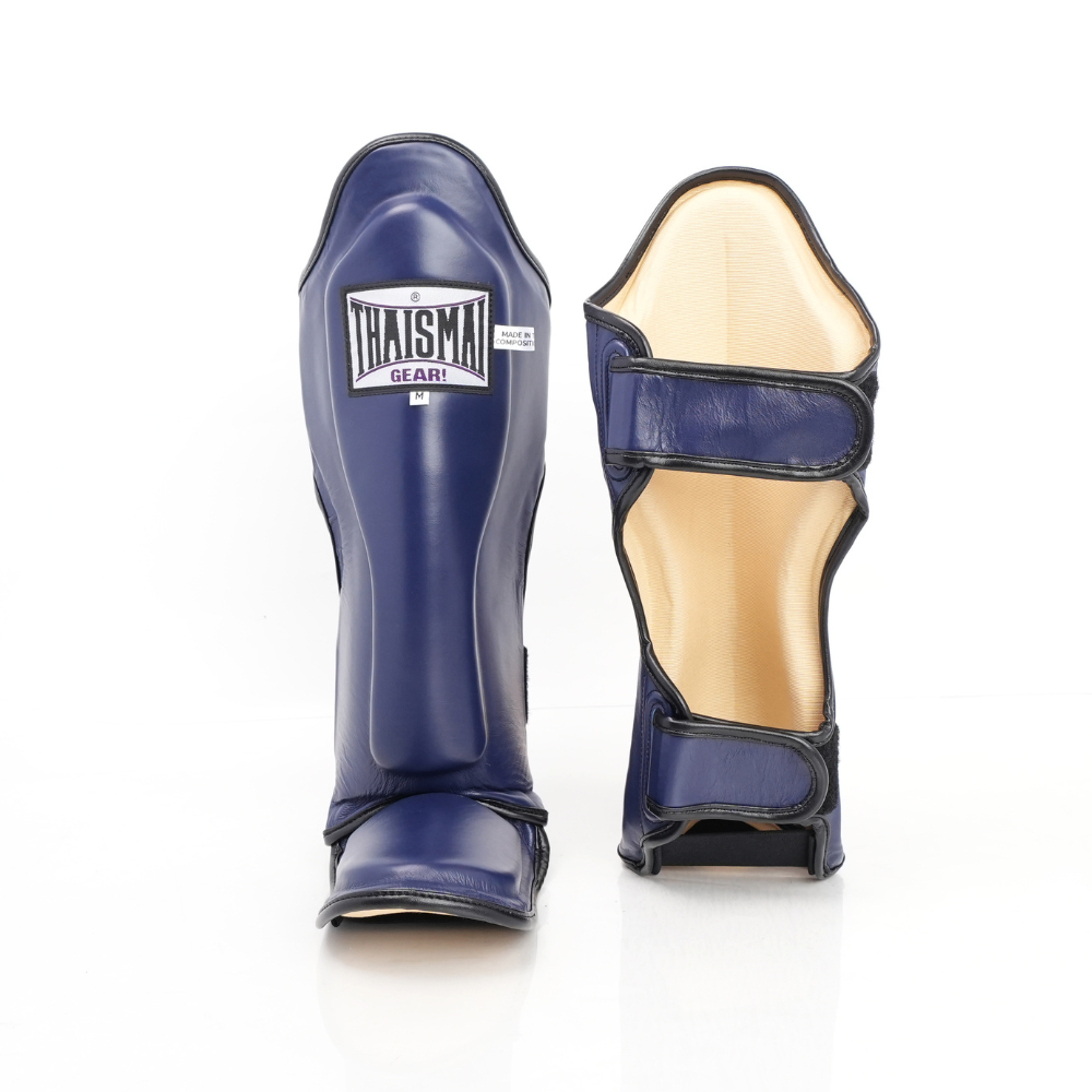 Front and rear views of the navy blue THAISMAI LP184 shin guards, showing the padded shin panel with brand patch, foot guard, light lining and fastening straps.