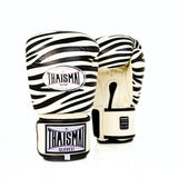 Front view of a pair of white and black ThaiSmai FBG124-Zebra Muay Thai boxing gloves showing the zebra-striped padded knuckles and THAISMAI wrist branding on a white background