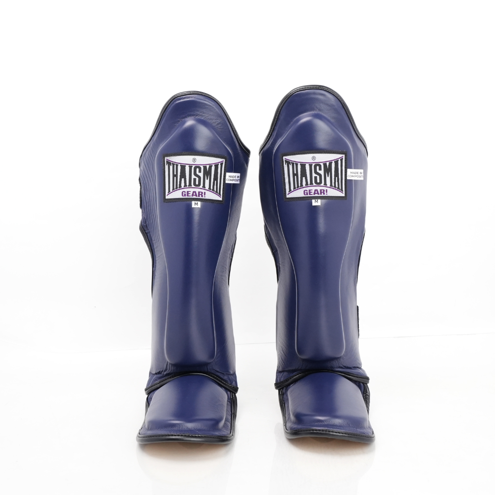 Front view of the navy blue THAISMAI LP184 Muay Thai shin guards, showing the padded shin panels, brand labels and foot sections against white.