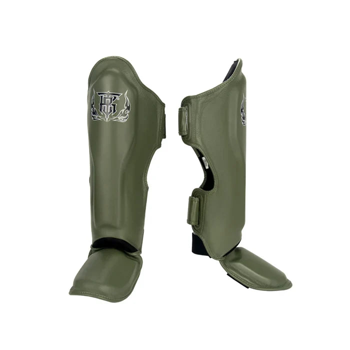 Top King TKSGP-GL Pro shin guards in black genuine leather with full-length shin and instep protection, dense impact padding and secure hook-and-loop closures for Muay Thai and kickboxing on a white background