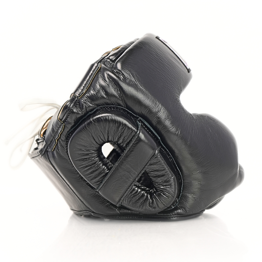 Side profile of the black THAISMAI HG-152 Muay Thai sparring head guard showing padded ear and cheek guards on a white background