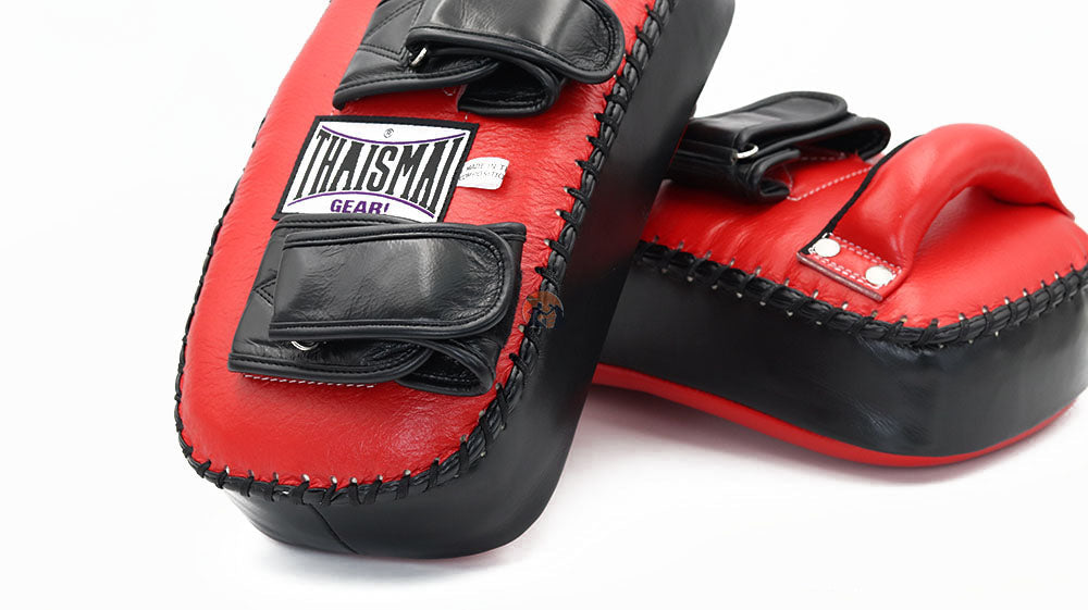 Close view of THAISMAI KP142 Muay Thai kick pads in red and black, showing the padded faces, stitching and double arm straps.
