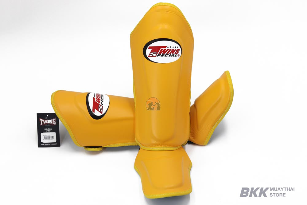 Twins Special SGL-10 shin guards in black synthetic leather with full-length shin and instep protection, secure hook-and-loop straps and padded support for Muay Thai and kickboxing training on a white background
