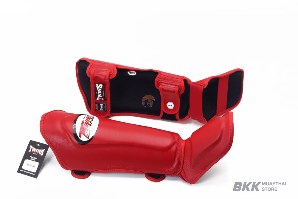 Twins Special SGL-10 shin guards in black synthetic leather with full-length shin and instep protection, secure hook-and-loop straps and padded support for Muay Thai and kickboxing training on a white background