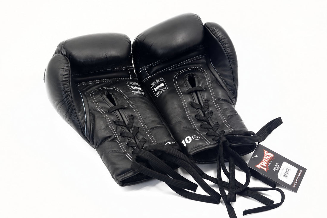 Twins Special BGLL-1 lace-up boxing gloves in black leather with secure lace closure, attached thumbs, and competition-style padding on a white background