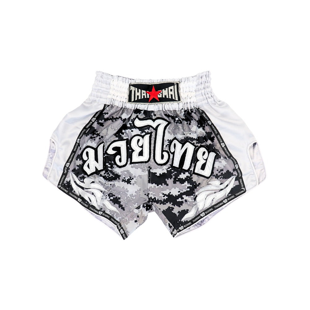 Back view of THAISMAI Muay Thai shorts in black, grey and white digital camouflage with white side panels, elastic waistband, Thai script and THAISMAI branding on a white background