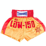 Front view of gold and red ThaiSmai M-150 Golden Era Muay Thai shorts showing the elastic waistband, red side panels and M-150 crest design on a white background