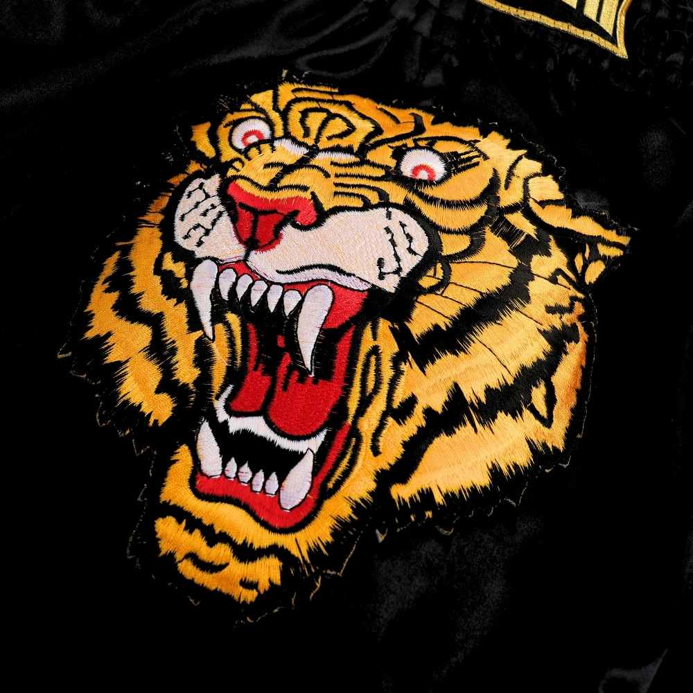 Additional view of black and yellow ThaiSmai TIGER Muay Thai shorts showing the lightweight satin construction and wide side slits on a white background