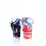 Angled view of a pair of Twins Special FBGVL4-67 SAK YANT boxing gloves showing red, white and blue tiger artwork on one glove, blue and purple leather panels on the other, and secure hook-and-loop wrist closures for boxing and Muay Thai on a white background