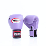 Pair of lavender Twins Special boxing gloves showing the front logo and rear glove with black wrist strap and branded wrist patch on a white background