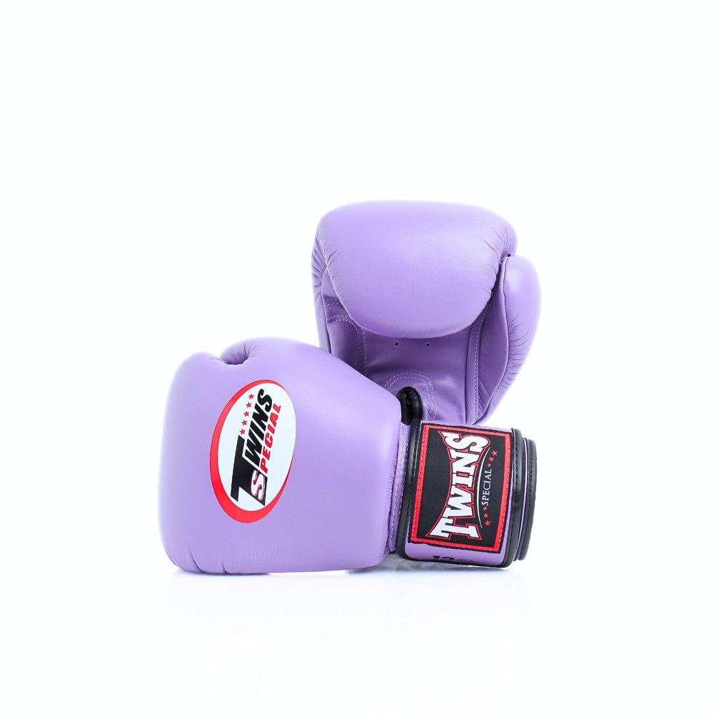 Pair of lavender Twins Special boxing gloves arranged at an angle, with the front glove showing the Twins logo and branded wrist patch on a white background