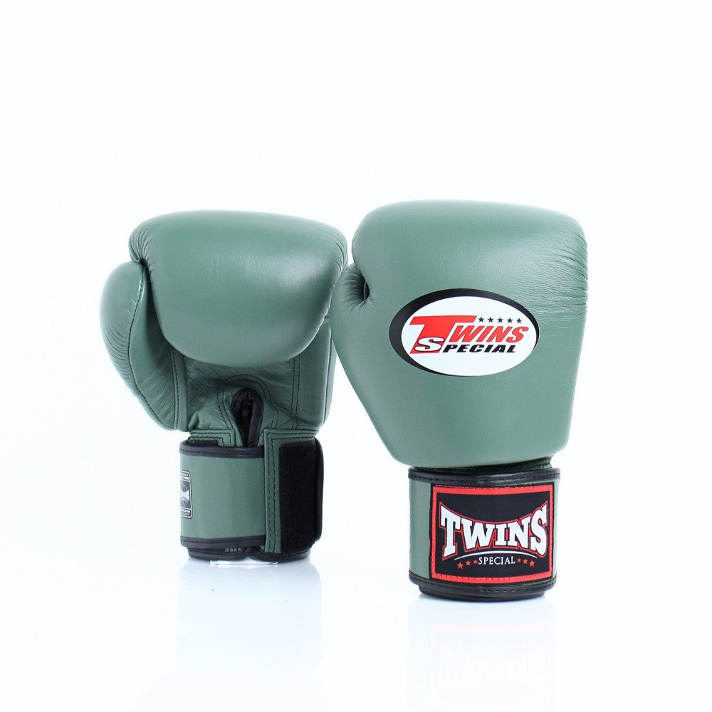 Pair of olive green Twins Special boxing gloves showing the rear glove and front glove with Twins logo, black wrist straps and branded wrist patch on a white background