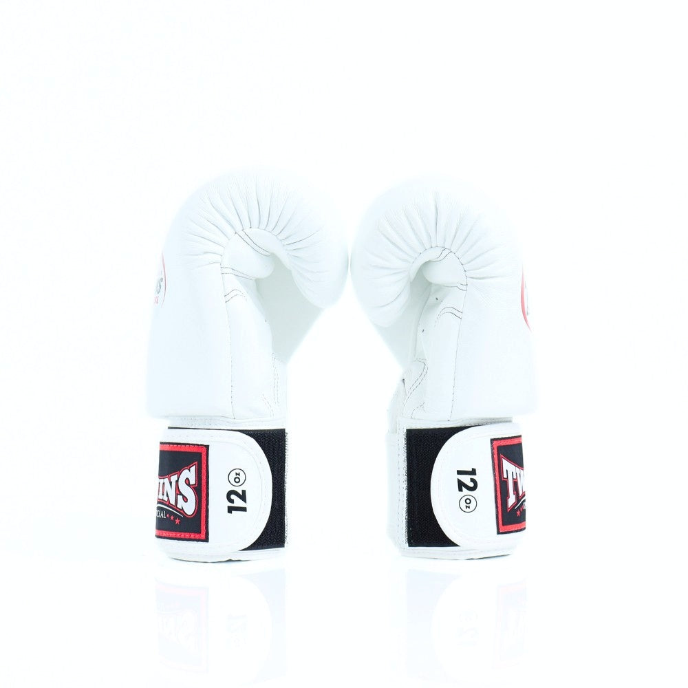 Pair of white Twins Special boxing gloves displayed side-by-side with black and red 12 oz wrist patches on a white background
