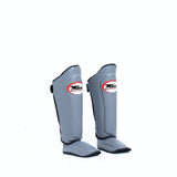 Twins Special SGL-10 shin guards in black synthetic leather with full-length shin and instep protection, secure hook-and-loop straps and padded support for Muay Thai and kickboxing training on a white background