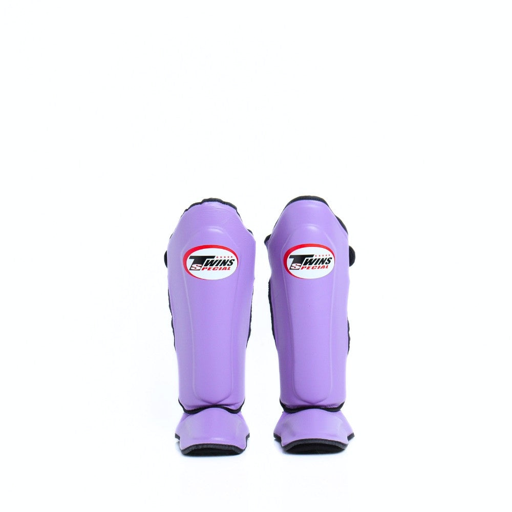 Twins Special SGL-10 shin guards in black synthetic leather with full-length shin and instep protection, secure hook-and-loop straps and padded support for Muay Thai and kickboxing training on a white background