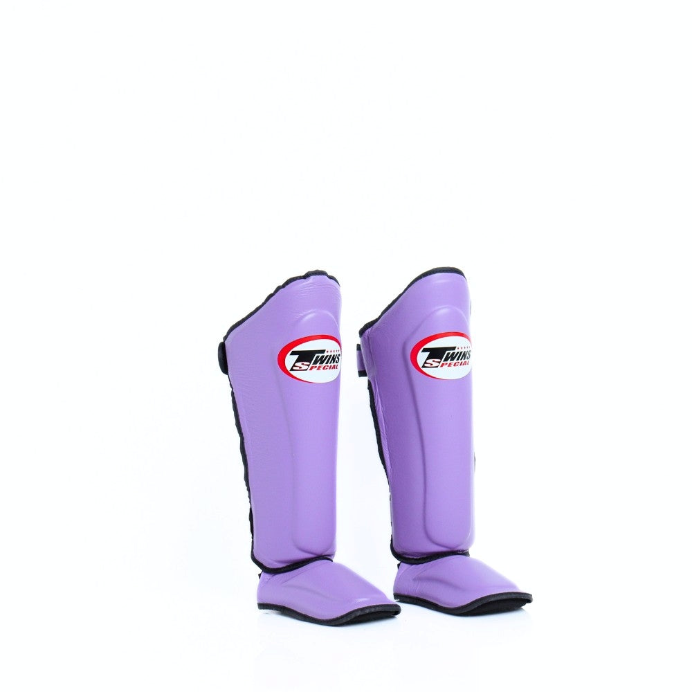 Twins Special SGL-10 shin guards in black synthetic leather with full-length shin and instep protection, secure hook-and-loop straps and padded support for Muay Thai and kickboxing training on a white background