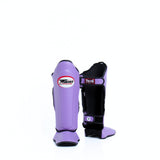 Twins Special SGL-10 shin guards in black synthetic leather with full-length shin and instep protection, secure hook-and-loop straps and padded support for Muay Thai and kickboxing training on a white background
