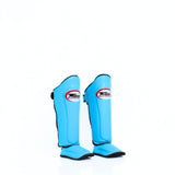 Twins Special SGL-10 shin guards in black synthetic leather with full-length shin and instep protection, secure hook-and-loop straps and padded support for Muay Thai and kickboxing training on a white background