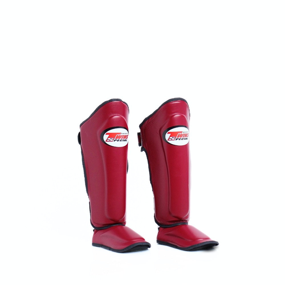 Twins Special SGL-10 shin guards in black synthetic leather with full-length shin and instep protection, secure hook-and-loop straps and padded support for Muay Thai and kickboxing training on a white background