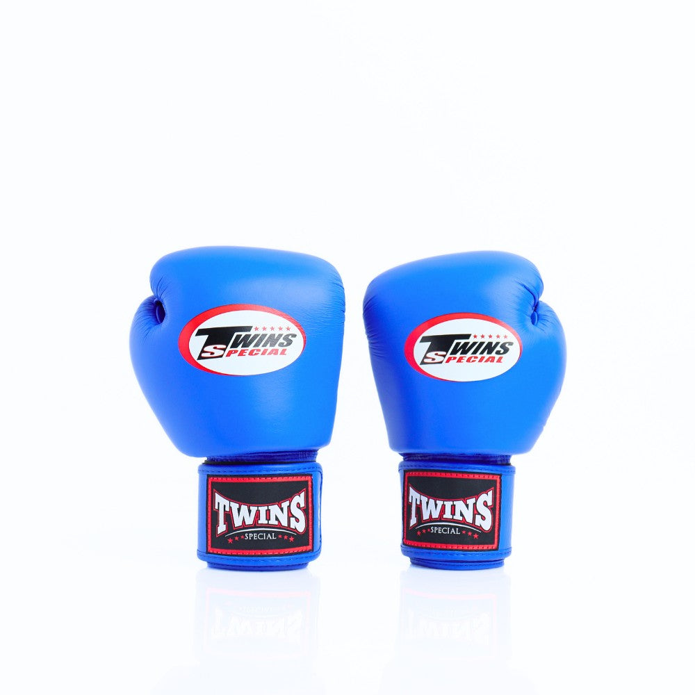 Pair of bright blue Twins Special boxing gloves shown front-facing with Twins logos and branded red-and-black wrist patches on a white background