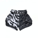 Twins Special TBS-JUNGLE Muay Thai boxing shorts with black and white tiger-stripe and dark textured jungle design, traditional side-slit cut and secure elastic waistband on a white background