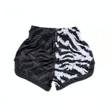 Twins Special TBS-JUNGLE Muay Thai boxing shorts with black and white tiger-stripe and dark textured jungle design, traditional side-slit cut and secure elastic waistband on a white background
