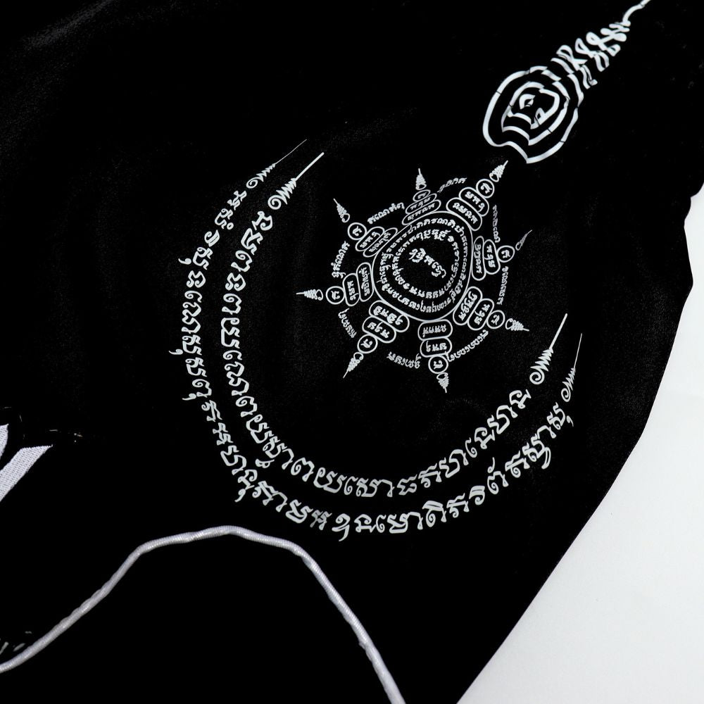 Front view of black and yellow ThaiSmai TIGER Muay Thai shorts with bold tiger artwork, elastic waistband and traditional side-slit cut on a white background
