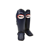 Twins Special SGL-10 shin guards in black synthetic leather with full-length shin and instep protection, secure hook-and-loop straps and padded support for Muay Thai and kickboxing training on a white background