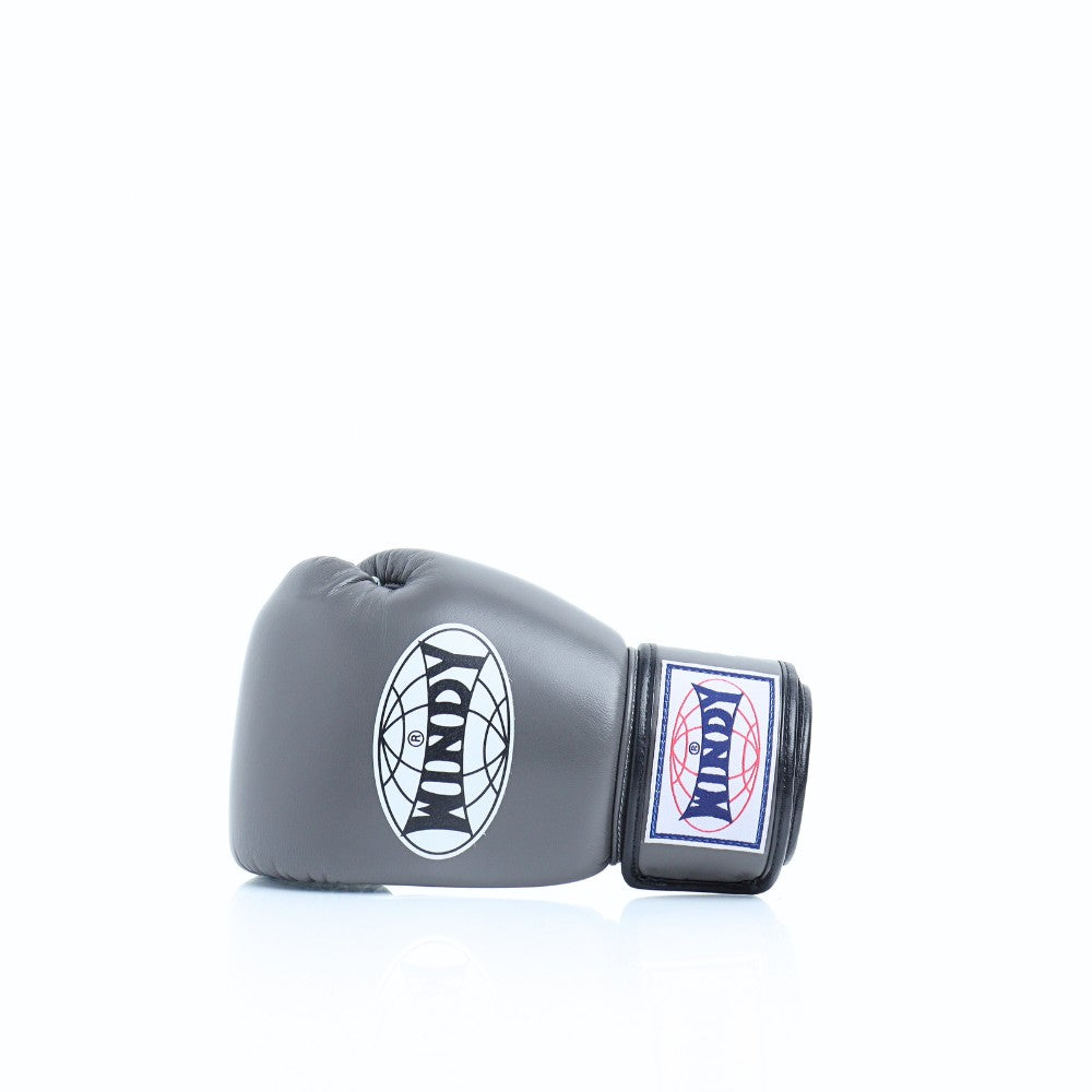 Angled view of grey Windy BGVH Muay Thai boxing gloves showing padded knuckles, thumb guard, leather construction and secure wrist closure on a white background