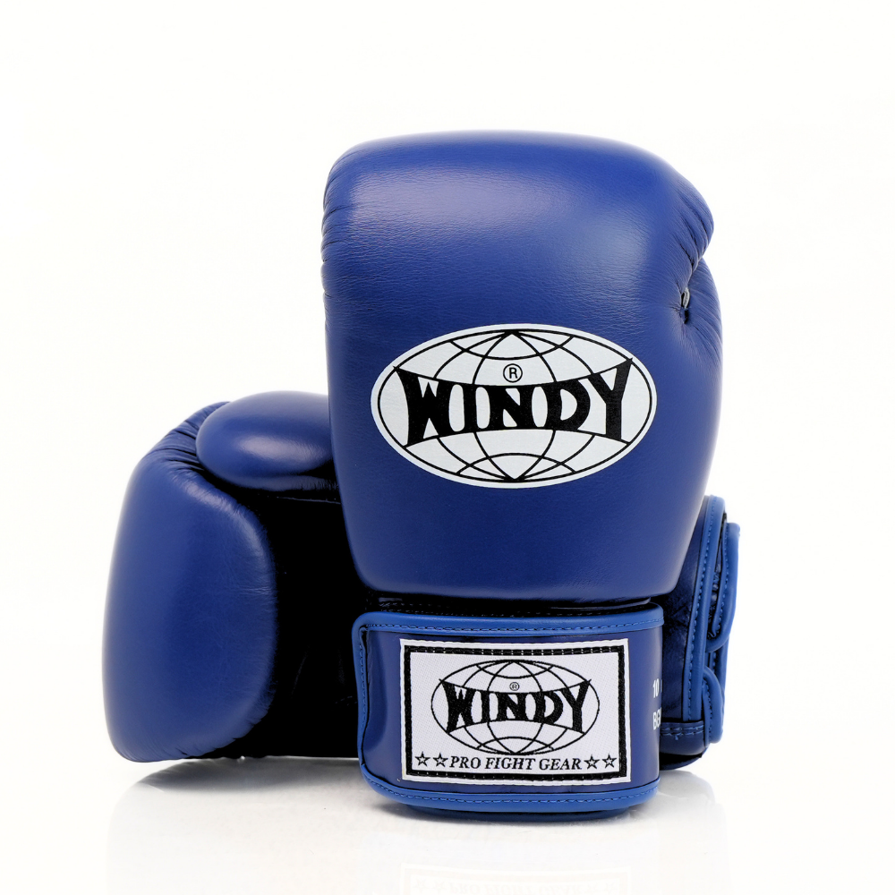 Side view of blue Windy BGVH Muay Thai boxing gloves showing the padded glove profile, thumb guard and extended wrist cuff on a white background