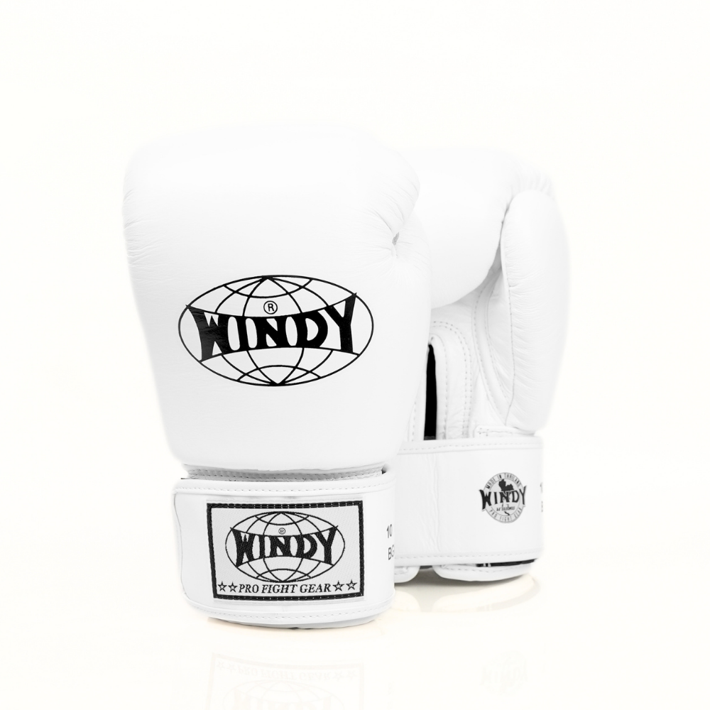 Angled front view of white Windy BGVH leather Muay Thai boxing gloves showing the padded glove profile, Windy branding and wrist straps on a white background