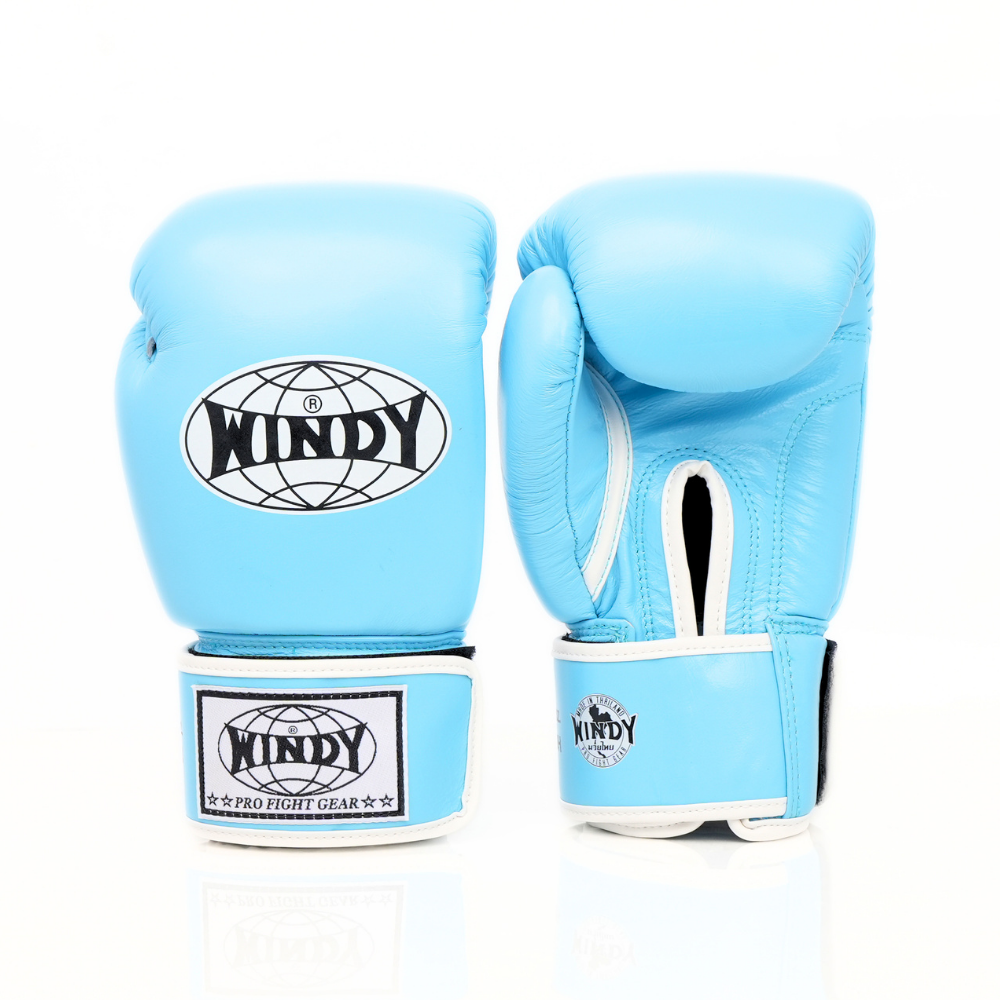 Side view of light blue Windy BGVH Muay Thai boxing gloves showing the padded glove profile, thumb guard and extended wrist cuff on a white background