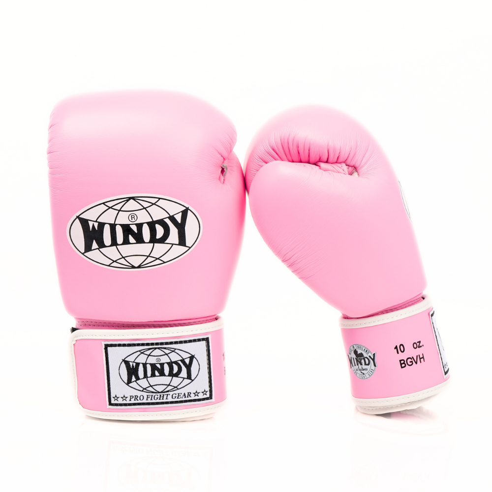 Angled view of light pink Windy BGVH Muay Thai boxing gloves showing padded knuckles, thumb protection, wrist cuffs and Windy branding on a white background