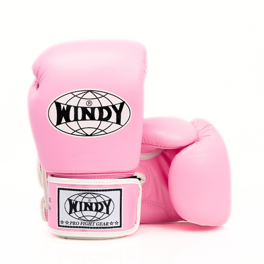Side view of light pink Windy BGVH Muay Thai boxing gloves showing the padded glove profile, thumb guard and extended wrist cuff on a white background