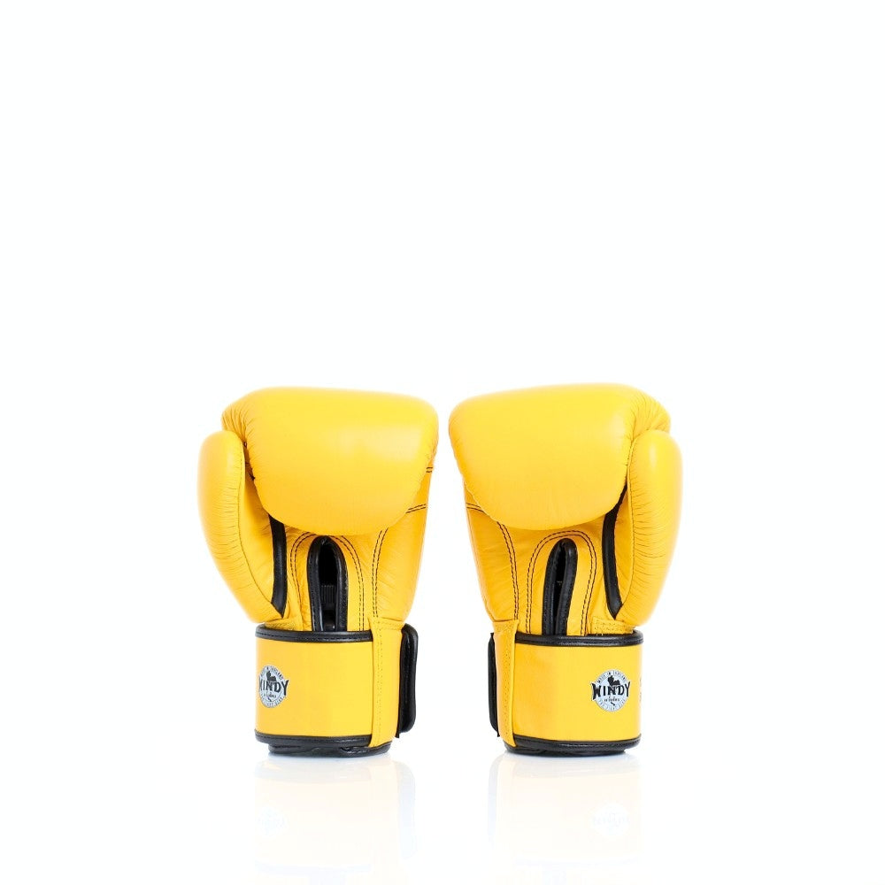 Angled view of yellow Windy BGVH leather Muay Thai boxing gloves showing the padded glove profile, wrist closures and Windy branding on a white background