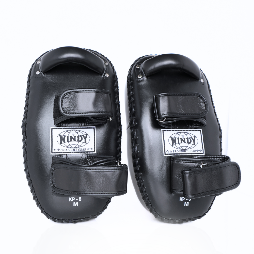 Front view of a pair of black Windy KP-8 leather kick pads showing double straps, padded striking surfaces and Windy logos on a white background