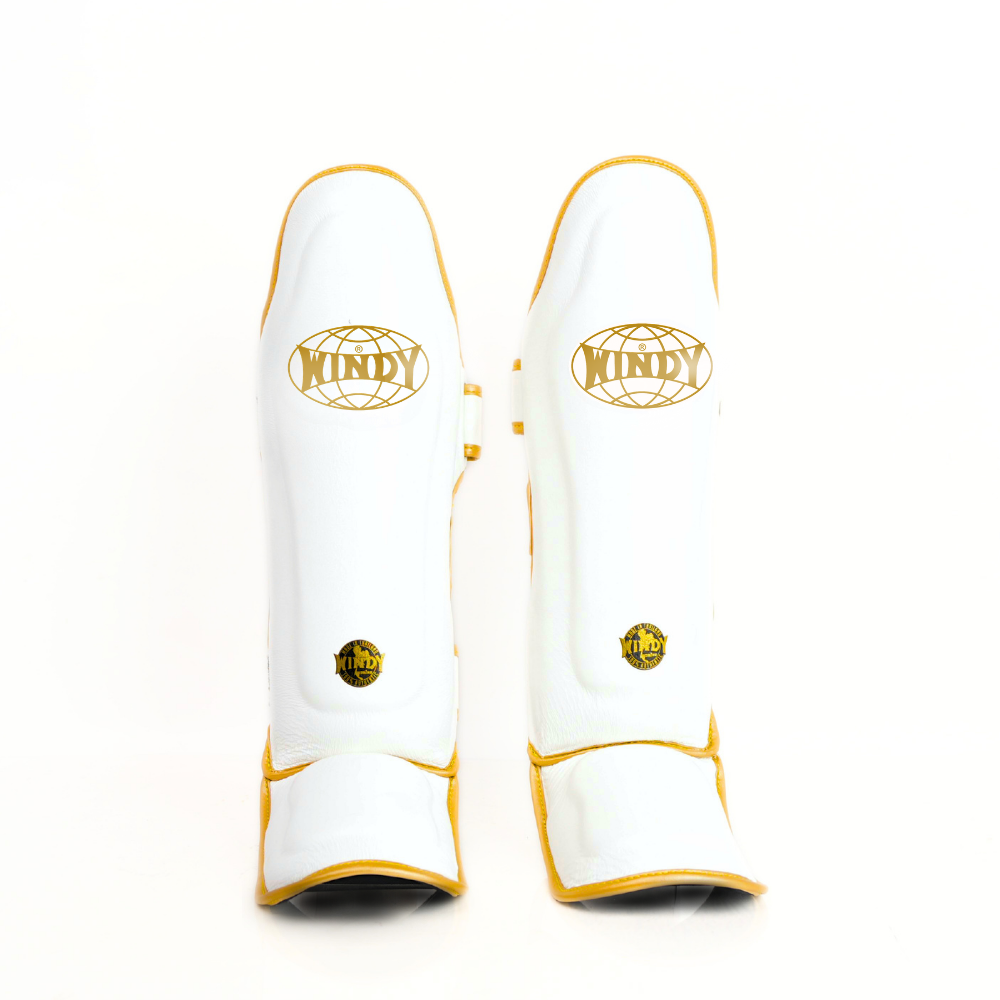 Windy LP3 white and gold Muay Thai shin guards with full-length leg and instep protection, padded shin support and Windy branding on a white background