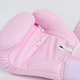 Close-up of a light pink Twins Special boxing glove showing the padded knuckle area, stitched palm, ventilation holes and thumb opening