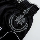 THAISMAI SAK YANT Muay Thai boxing shorts in lightweight satin with Thai lettering, classic side-slit cut and traditional fightwear design on a white background