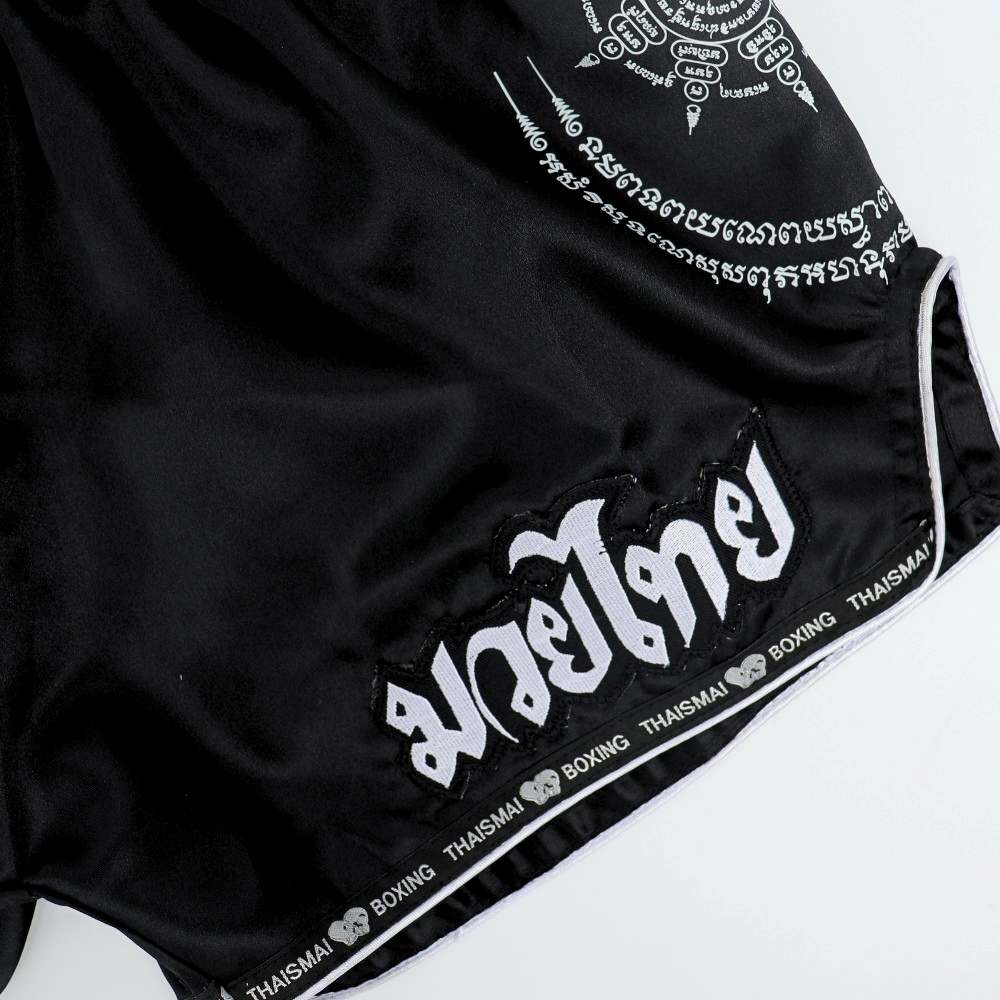 THAISMAI SAK YANT Muay Thai boxing shorts in lightweight satin with Thai lettering, classic side-slit cut and traditional fightwear design on a white background