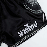 THAISMAI SAK YANT Muay Thai boxing shorts in lightweight satin with Thai lettering, classic side-slit cut and traditional fightwear design on a white background